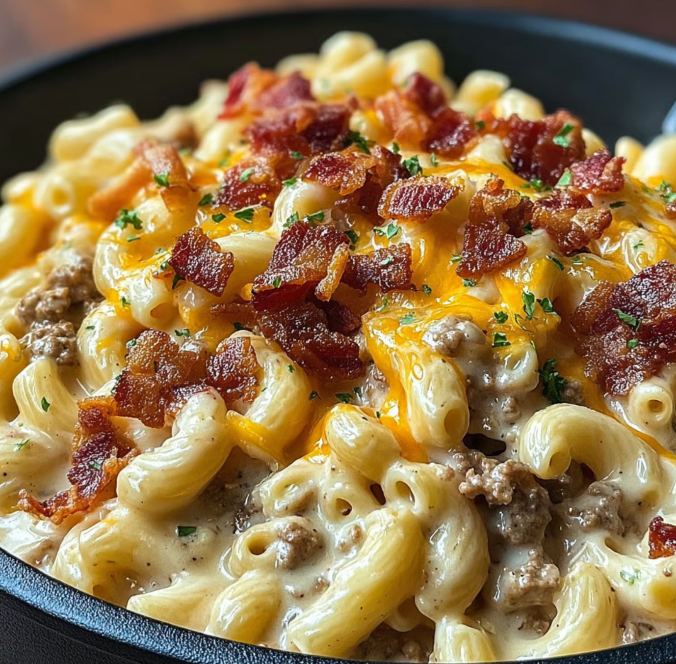 A bowl of macaroni and cheese with bacon bits on top.
