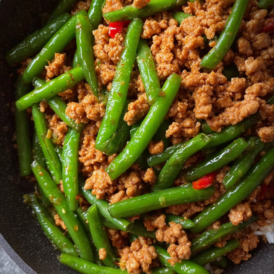 A bowl of meat and green beans, possibly a stir fry dish.