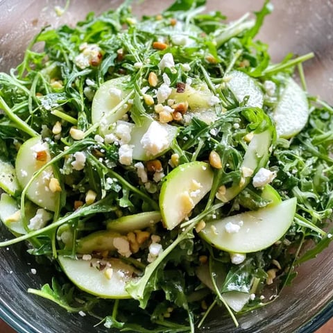 A bowl of salad with feta cheese and walnuts.