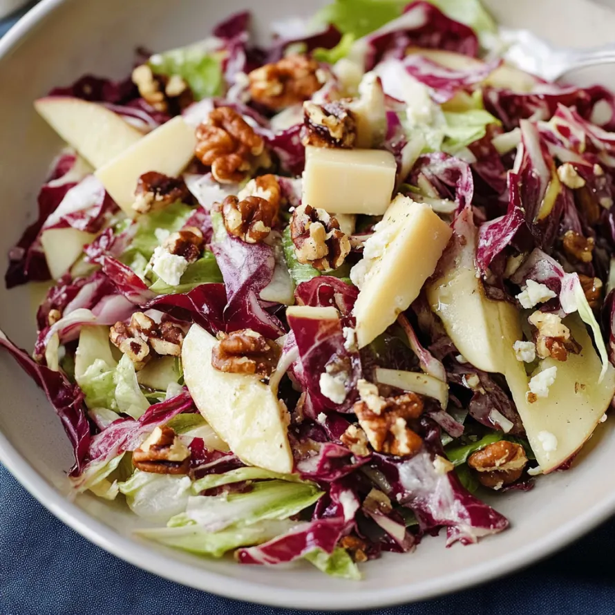 A bowl of salad with walnuts and apples.