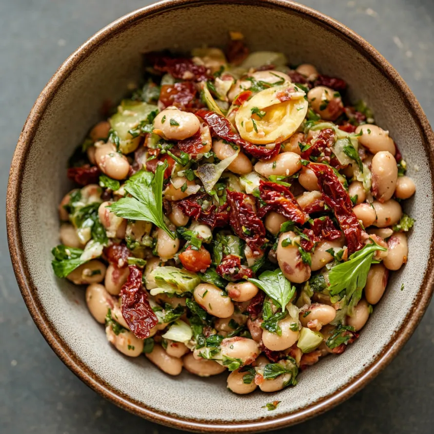 A bowl of food with beans, tomatoes, and lettuce.