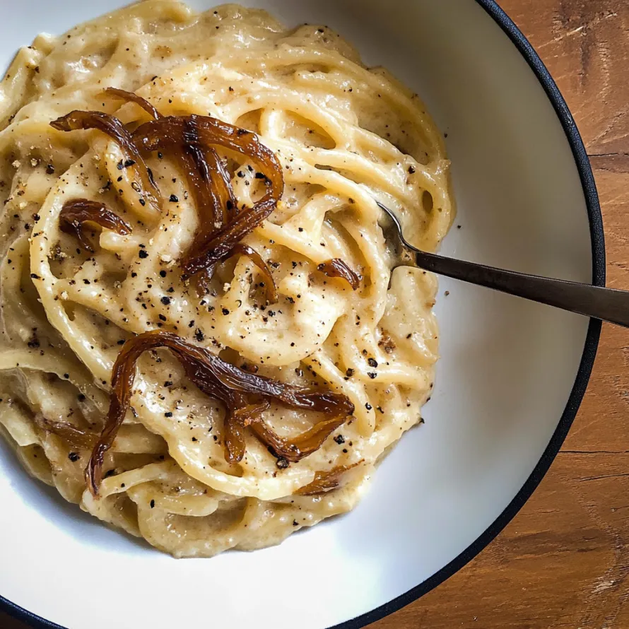 A bowl of pasta with onions.