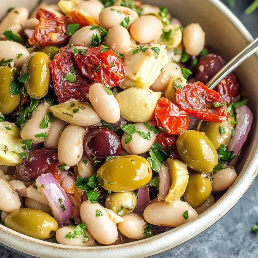 A bowl of food with olives, beans, and tomatoes.