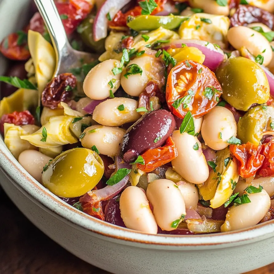 A bowl of food with green beans, tomatoes, and olives.