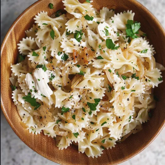 A bowl of pasta with onions and cheese.