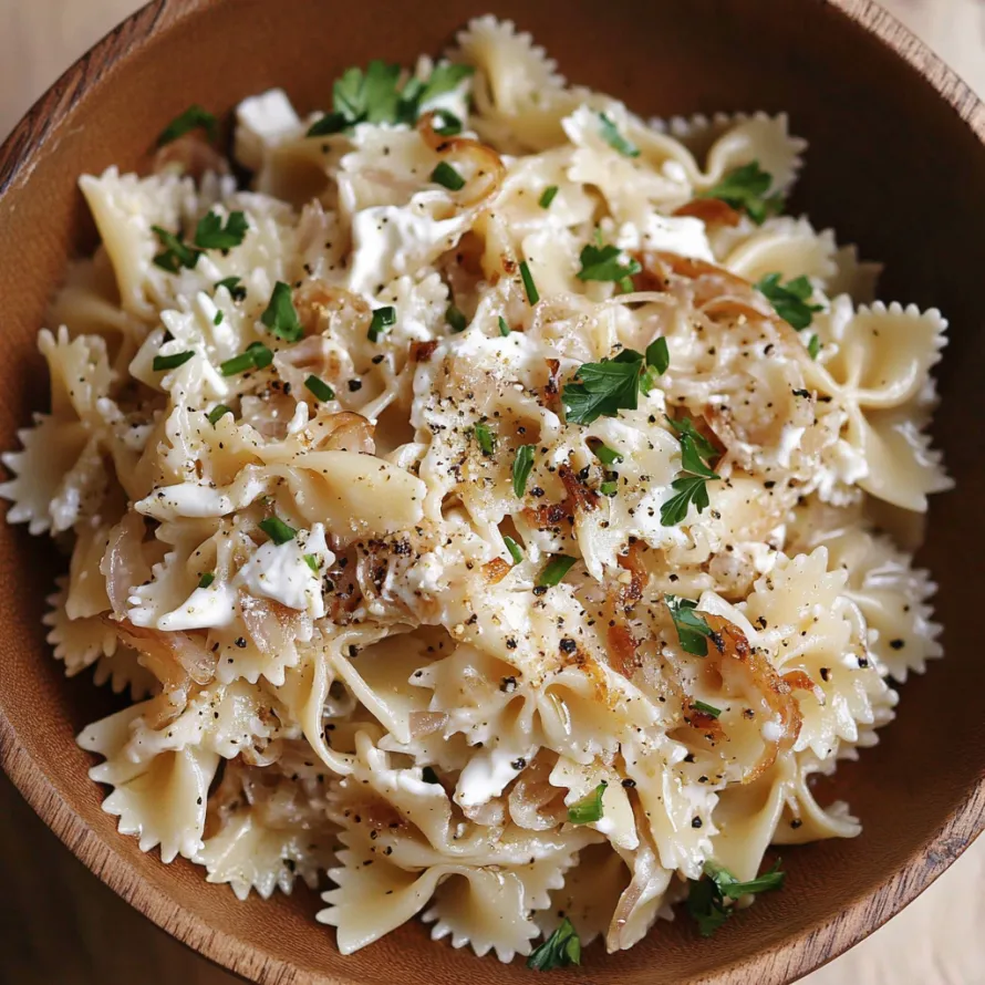 A bowl of pasta with cheese and herbs.