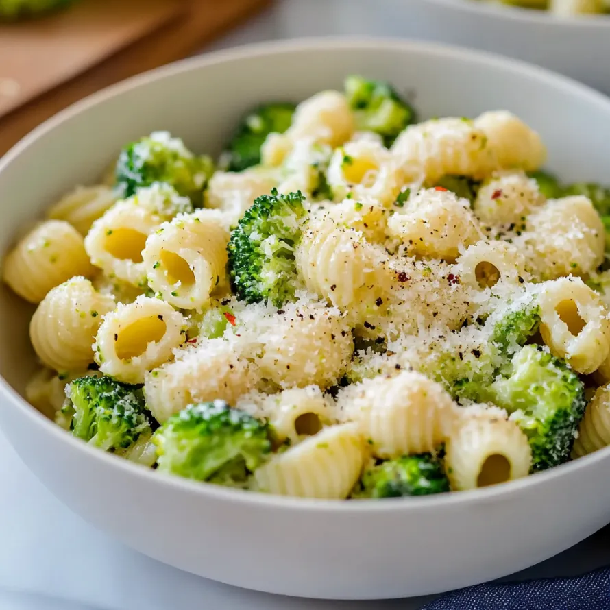 A bowl of pasta with broccoli and cheese.