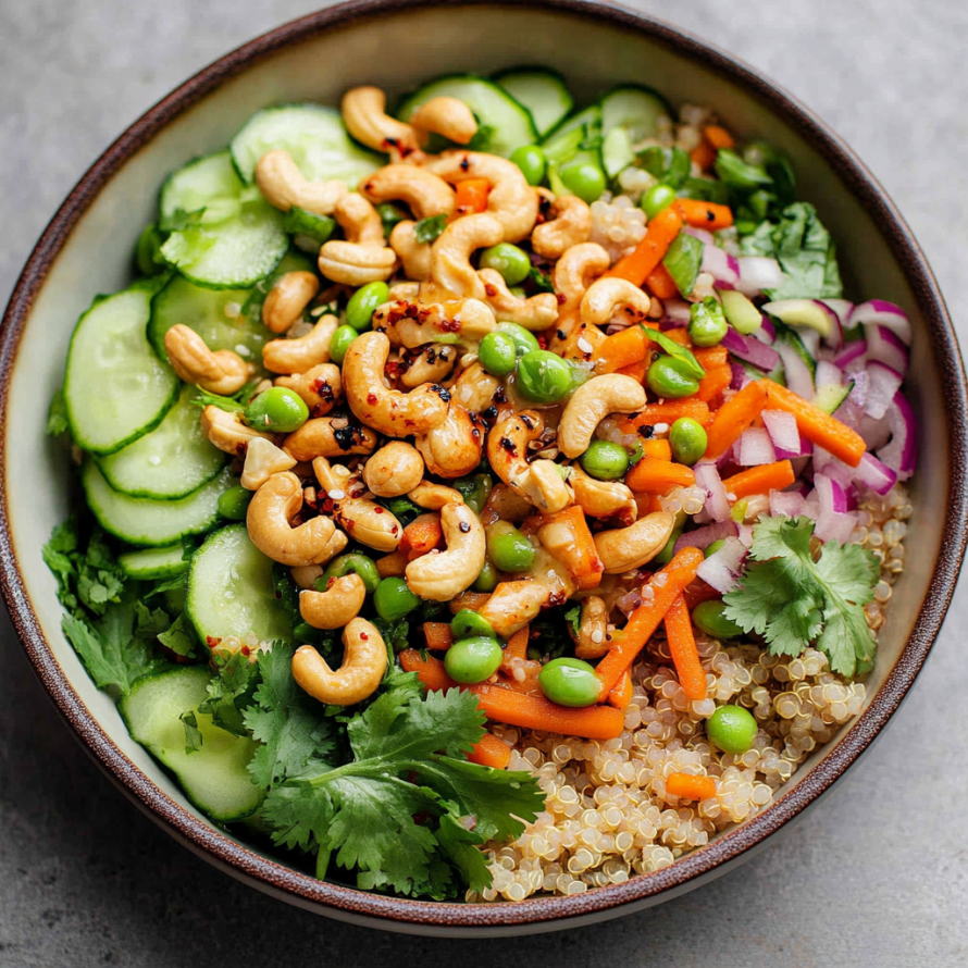 A bowl of vegetables, including carrots, cucumbers, and peas, is topped with nuts and served with a side of rice.