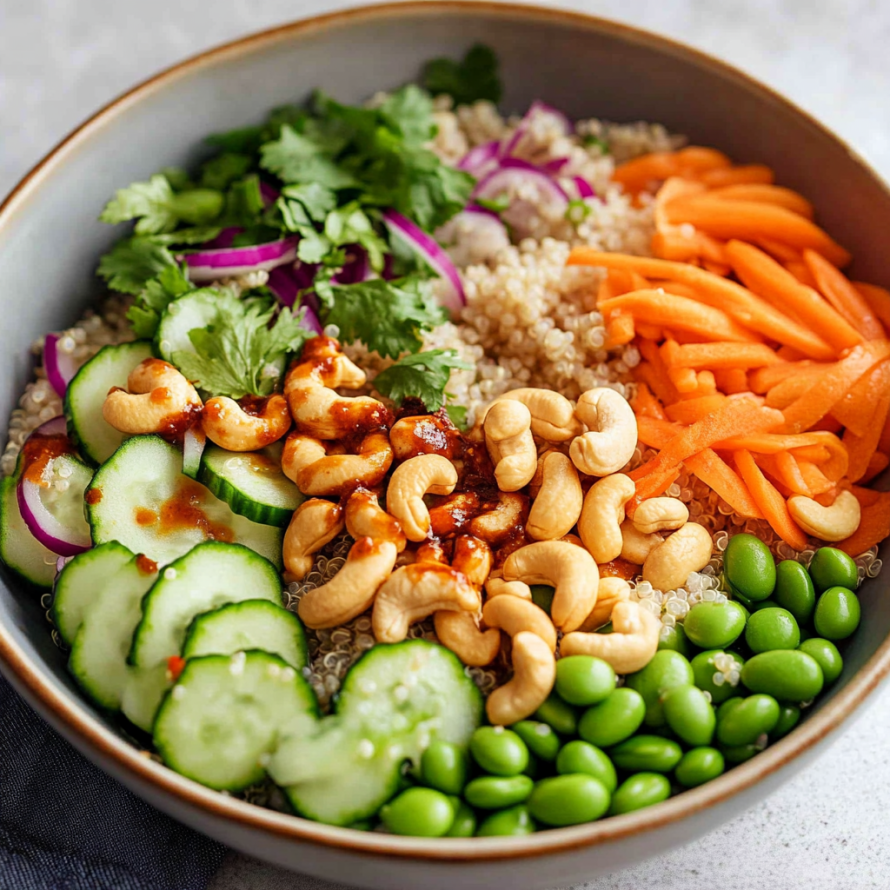 A bowl filled with a variety of vegetables, including cucumbers, carrots, and peas, along with nuts and rice.