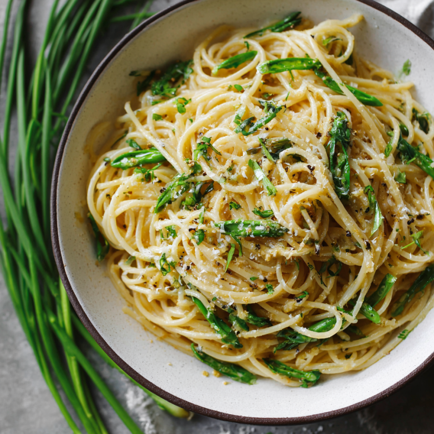 A bowl of pasta with green vegetables and cheese, possibly a dish called "Penne alla Pesto.