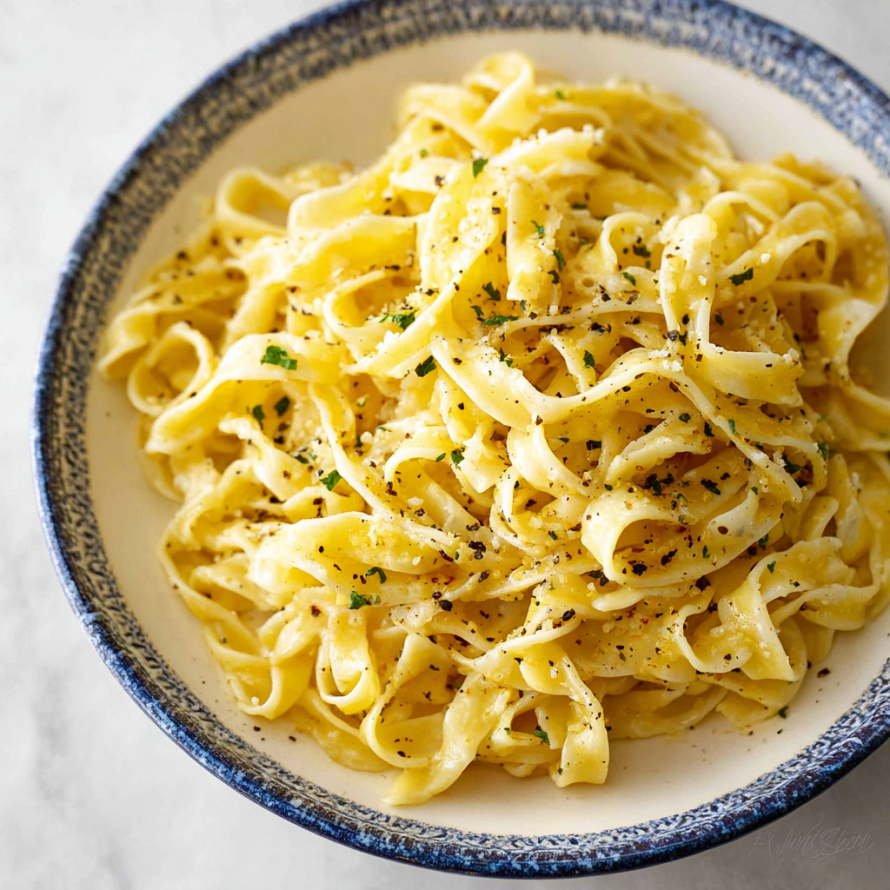A bowl of pasta with a lemon pepper sauce.