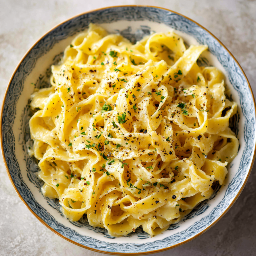 A bowl of pasta with cheese and herbs on top.
