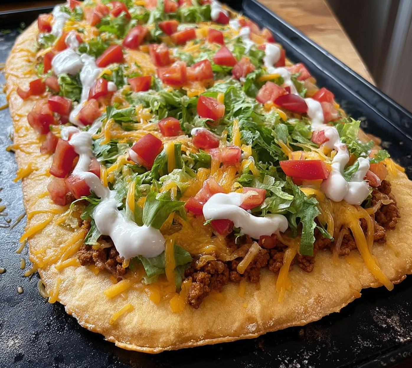 A delicious Taco Pizza with cheese, tomatoes, lettuce, and meat on top.