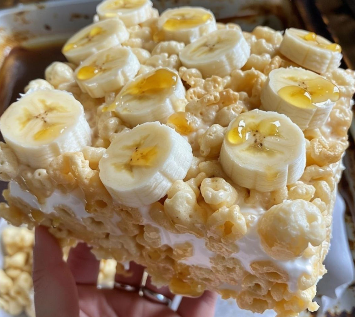 A person is holding a square of Banana Pudding Rice Krispies.
