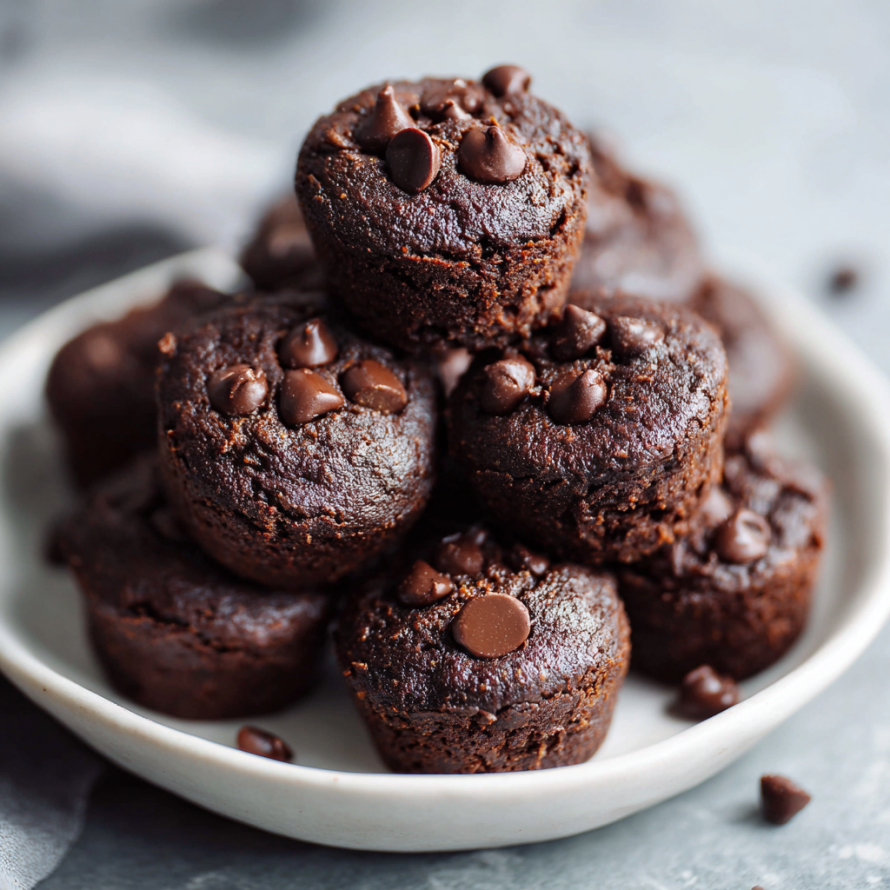 A plate of chocolate chip muffins with chocolate chips on top.