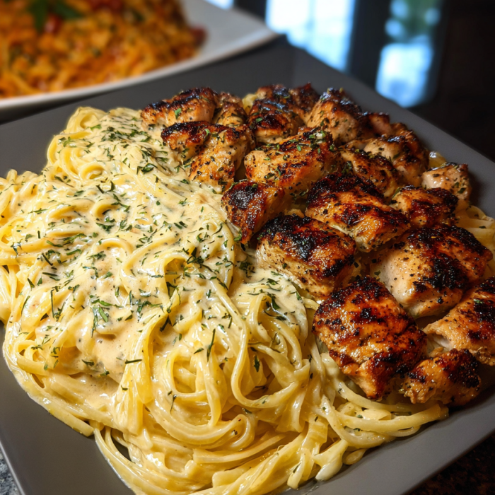 A plate of chicken and pasta with a creamy garlic butter sauce.