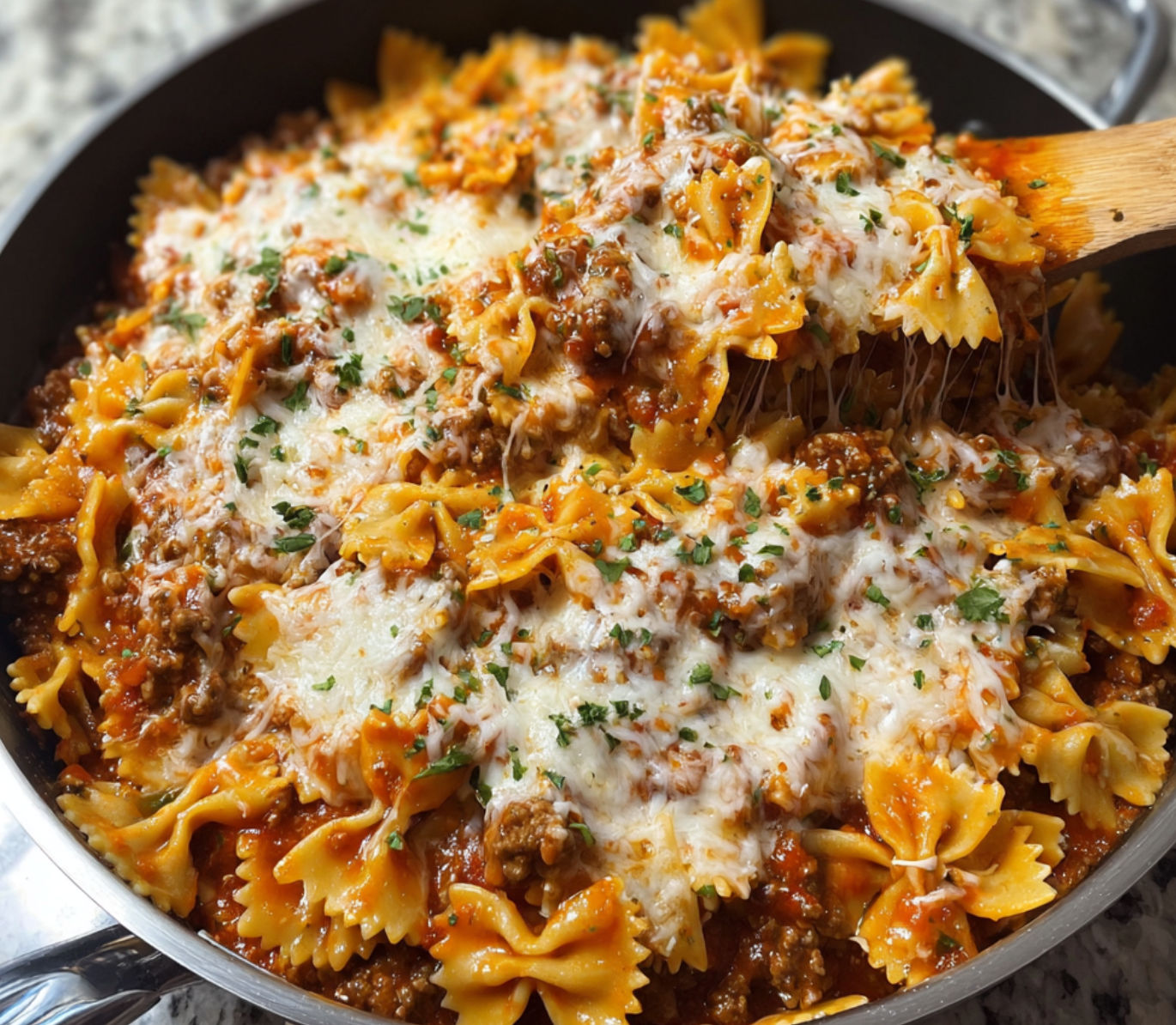 A delicious Creamy Velveeta Bowtie Pasta with Italian Beef Marinara is served in a silver bowl.
