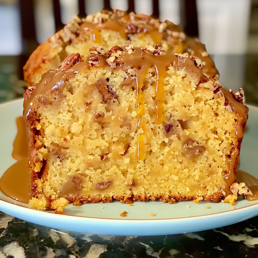 A slice of caramel pecan cake on a plate.