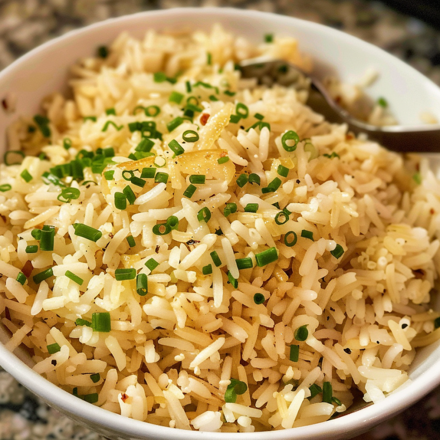 A bowl of rice with garlic and green onions, ready to be eaten.