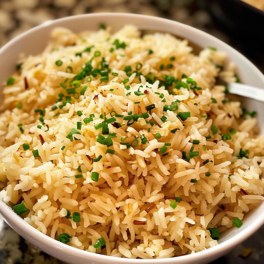 A bowl of rice with green onions on top, ready to be served.