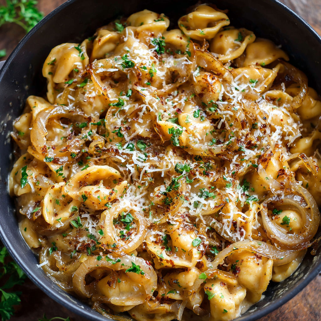 A bowl of pasta with cheese and onions, possibly a dish called "Cheesy Onion Pasta.