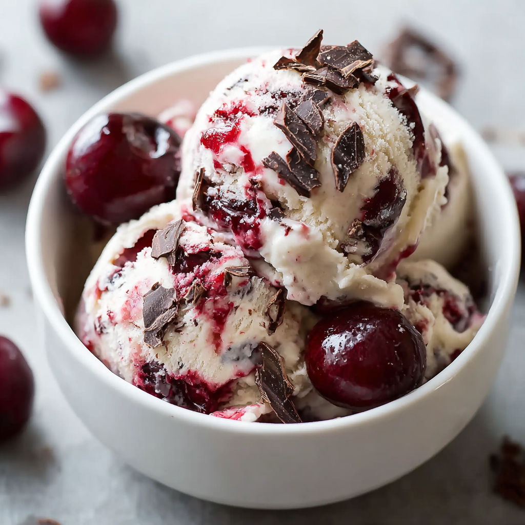 A bowl of chocolate ice cream with chocolate chips and cherries on top.