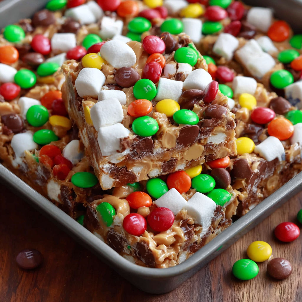 A pan of candy bars and marshmallows, including M&Ms, Reese's, and other candies.