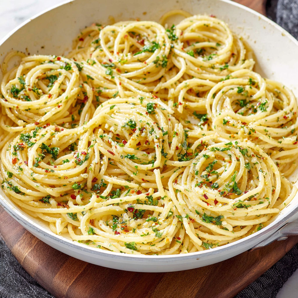 A pan of spaghetti with herbs and spices, ready to be served.