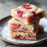 A stack of strawberry shortcake bars on a plate.