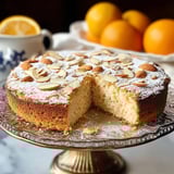 A slice of cake with almonds on a plate.