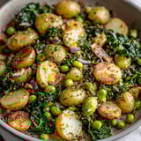 A bowl of vegetables including potatoes, peas, and greens.