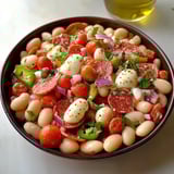 A bowl of food with tomatoes, beans, peppers, and cheese.