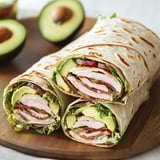 A sandwich with chicken, bacon, lettuce and avocado.
