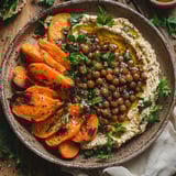 A bowl of food with carrots and chickpeas.