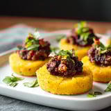 A plate of vegan polenta olive tapenade bites.