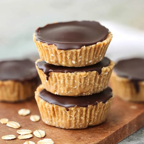 Chocolate covered peanut butter cups on a wooden table.