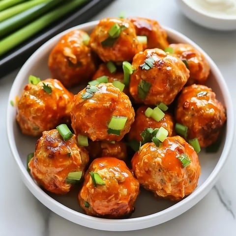 A bowl of meatballs with green onions on top.