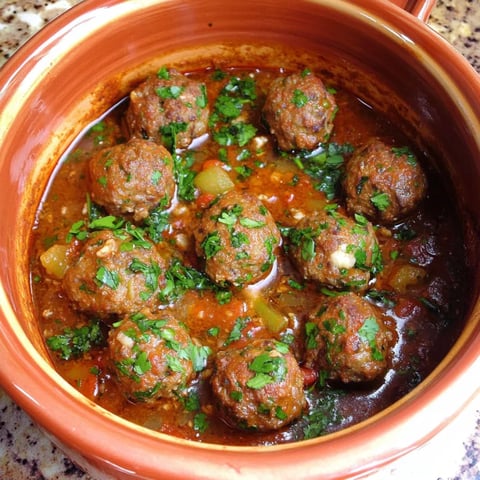 A bowl of meatballs in a red sauce.