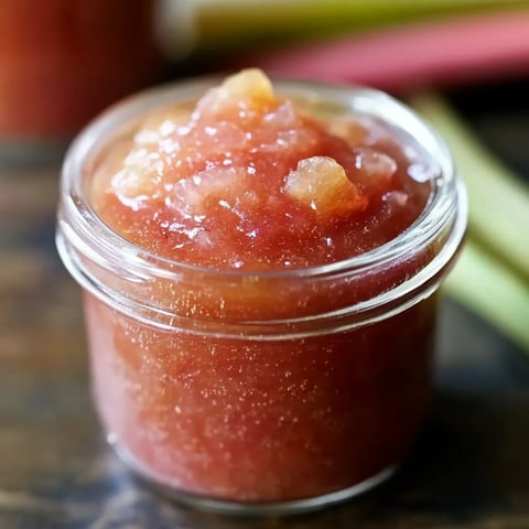 A jar of jam with a spoon in it.