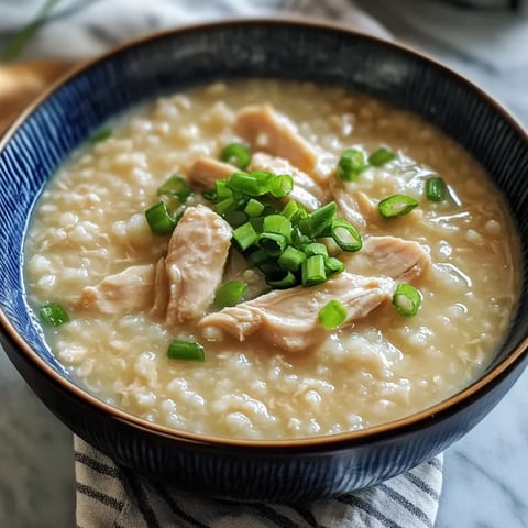 A bowl of soup with chicken and green onions.