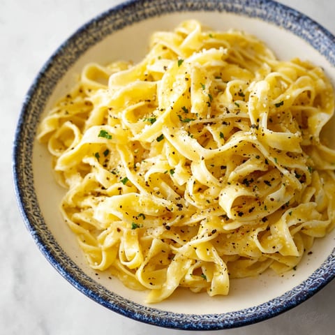 A bowl of pasta with a lemon pepper sauce.