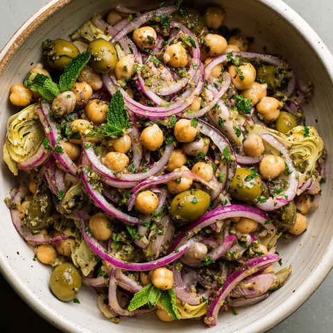 A bowl of Marinated Za'atar Bean Salad is displayed, featuring a mix of vegetables and beans.