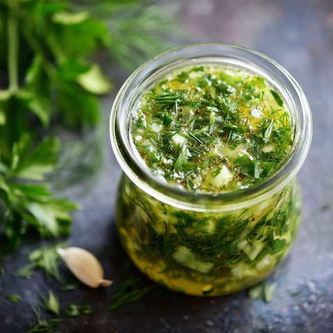 A jar of pickle juice salad dressing is displayed on a table.