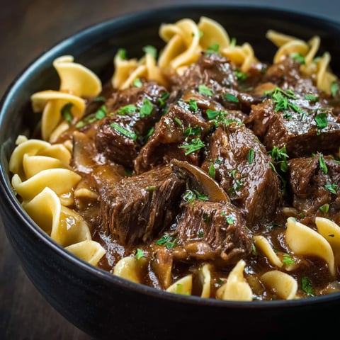 A bowl of beef and noodles, with a close-up of the meat and noodles.