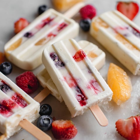 A close up of a popsicle with blueberries, strawberries, and raspberries.