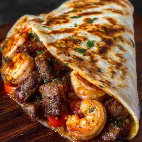 A delicious Creole Steak Shrimp Quesadilla is served on a wooden platter.