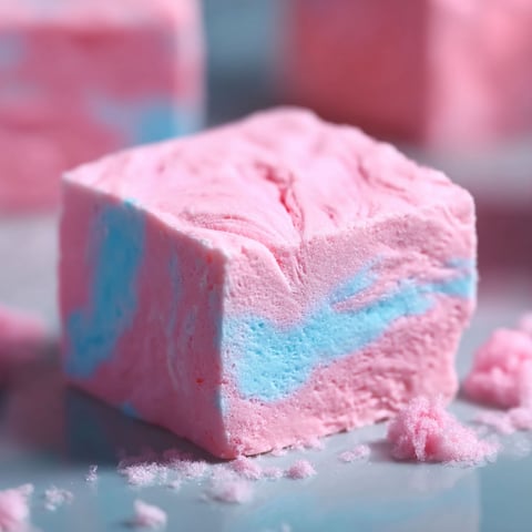 A piece of Cotton Candy Fudge with a swirl of pink and blue colors.