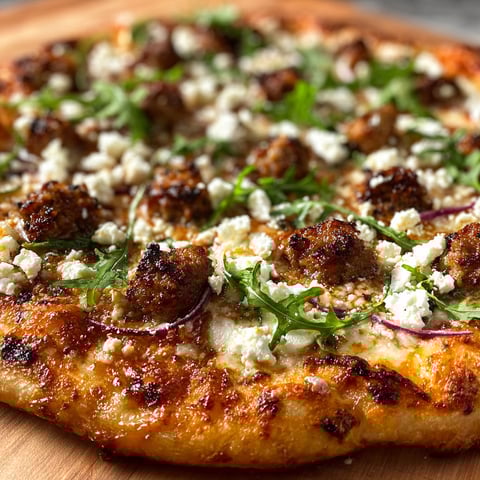 A Sweet & Spicy Hot Sausage Feta Honey Pizza with a generous amount of cheese and toppings.