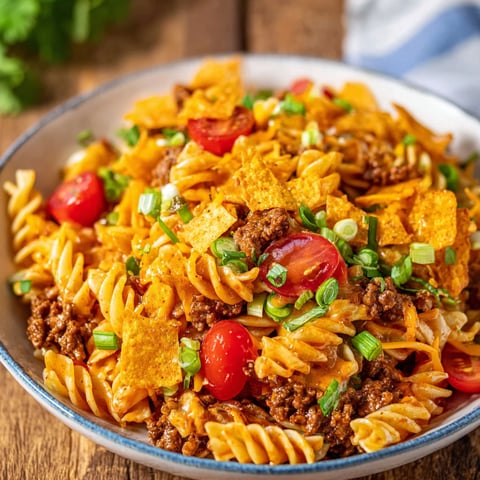 A bowl of Taco Pasta Salad is filled with pasta, tomatoes, and cheese, making for a delicious and satisfying meal.