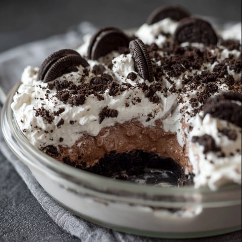 A close up of a delicious Oreo Mud Pie, with a white whipped cream topping and chocolate chips.